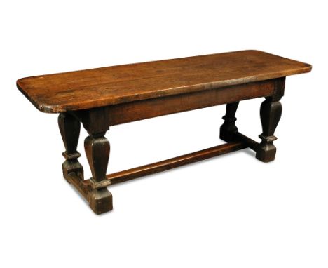 An oak refectory table - 17th century, the plank top with re-entrant shaped corners, on square baluster outline legs and late