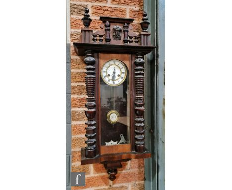 A late 19th to early 20th Century walnut cased Vienna style wall clock, with white enamelled dial and spring-driven movement,
