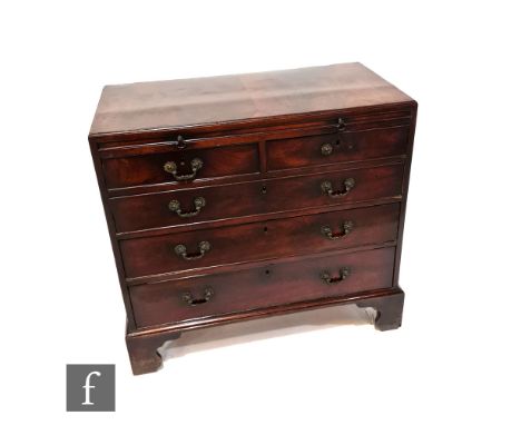 A George III mahogany batchelors chest, the brushing slide over two short and three long drawers, brass cast handles, on brac