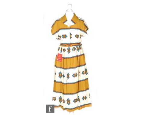 A 1950s ladies vintage dress in cream cotton with printed banded Aztec pattern in yellow, blue and pink, with cap sleeves, co