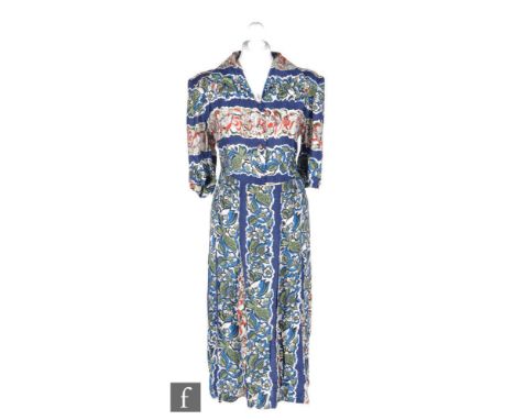 A 1940s CC41 Utility ladies vintage dress in blue with bands of floral patterns in red, blue, green and white, with short sle