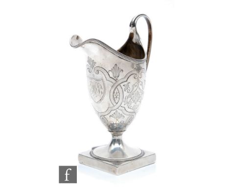 A George III silver cream jug of helmet form, with reeded rim and loop handle, engraved with foliate swags, acanthus scrolls 