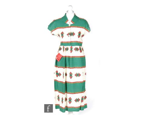 A 1950s ladies vintage dress in cream cotton with printed banded Aztec pattern in green yellow and red, with cap sleeves, col