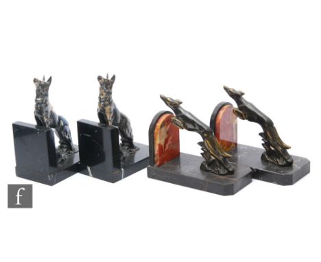 A pair of 20th Century Art Deco spelter bookends, decorated with stylised silvered Alsatians perched on a rocky ground, mount