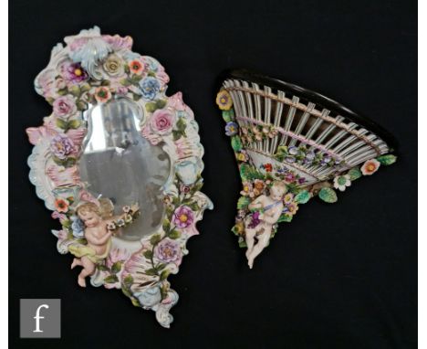 A late 19th to early 20th Century Dresden wall bracket with a seated cherub holding grapes and encrusted flowers affixed to a