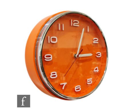 A vintage 1960s Metamec orange battery operated clock, the circular clock with relief Arabic numbers and chromed exterior, di