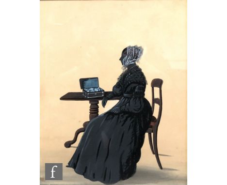 An early 19th Century painted silhouette portrait depicting a lady sitting at a table, in maple wood veneered frame, 26cm x 2