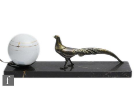 A French Art Deco table lamp decorated with a bronzed spelter peacock, with an opaque white sphere glass shade with gilt band