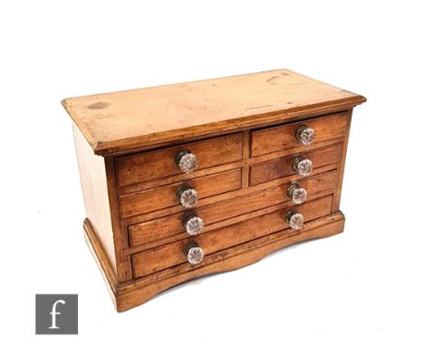 A 19th Century oak work or table cabinet fitted with an arrangement of four short and four long drawers, glass handles, on sh