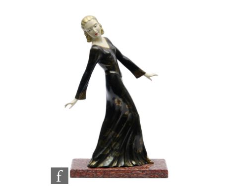 A 20th Century Art Deco painted spelter study, depicting a female figure in evening dress with gilt floral decoration, mounte