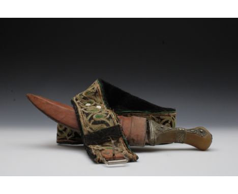 An Omani Jambiya Dagger and Belt from the 19th Century. Handle of Dagger made of Bone. L of Belt: 111cm H of Dagger: 31cm