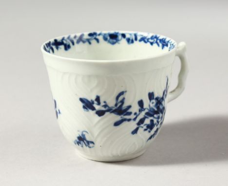 A WORCESTER BLUE AND WHITE HERRINGBONE MOULDED COFFEE CUP, painted with scattered flowers and a most unusual handle, workman'