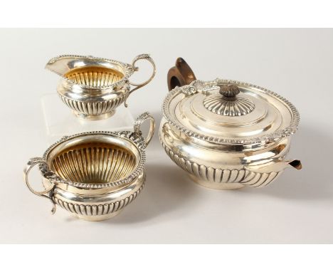 A THREE PIECE TEA SERVICE, comprising teapot, milk jug and sugar bowl, all with ribbed bodies. London 1917.  19ozs.