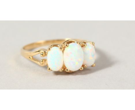 A 9CT GOLD THREE STONE OPAL RING.