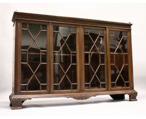 A GEORGE III DESIGN MAHOGANY LOW BOOKCASE, with dentil and blind fret cornice, four astragal glazed doors on carved ogee brac