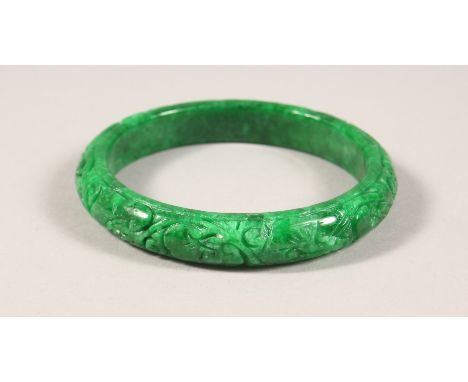 AN APPLE GREEN JADE BANGLE.&nbsp;3.25ins wide.