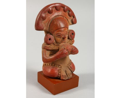 A PRE-COLUMBIAN STYLE POTTERY FIGURE ON STAND. 5.25ins high.