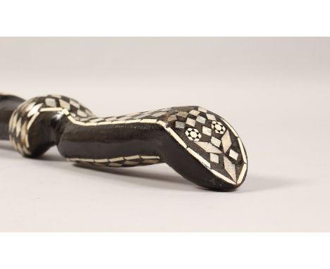 AN EBONISED CARVED WOOD SNAKE SHAPED WALKING STICK, with mother-of-pearl inlay. 36.5ins long.