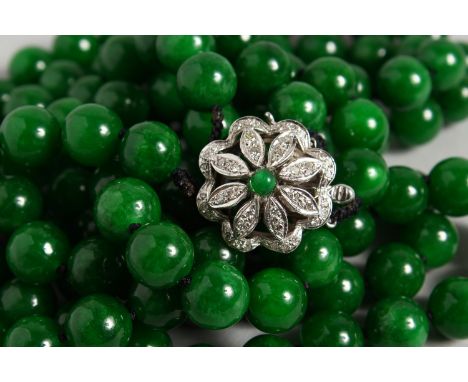 A GOOD DOUBLE ROW OF JADE BEADS, with 18ct white gold and diamond clasp. 25ins long.