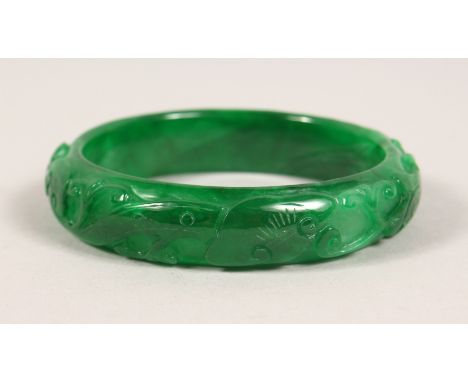 A CARVED APPLE GREEN JADE BANGLE. 3ins diameter.