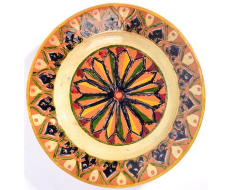 A Della Robbia Pottery Earthenware Dish, decorated with repeating patterns, in green, yellow, blue and red, painted Galleon m