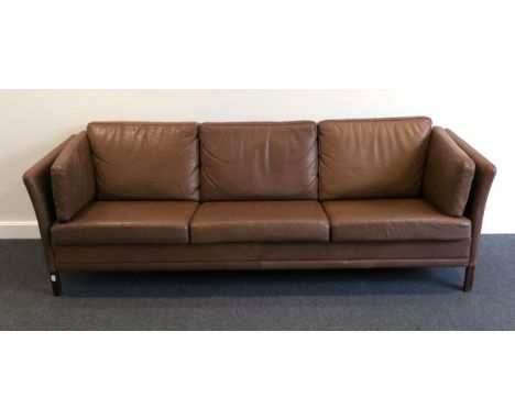 A 1970s Brown Leather Three-Seater Sofa, by Georg Thams, with slender arms above stained brown square form legs, 205cm by 71c