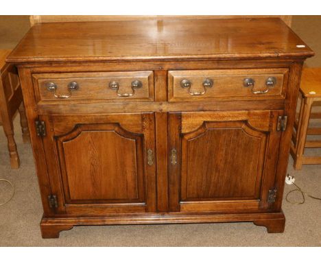 An Oak Sideboard, modern, with two long drawers above two cupboard doors, on bracket feet, 113cm by 47cm by 88cm