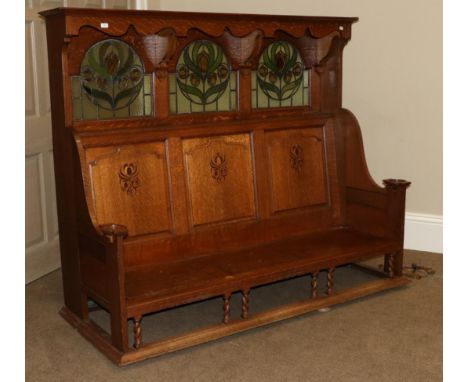 A Scottish Arts and Crafts Hall Bench, with overhanging cornice, above three stained glass panels, above three inlaid panelle