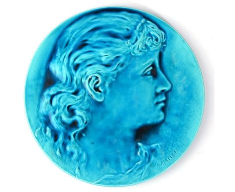 A Burmantofts Faience Pottery Circular Plaque, moulded with the portrait profile of a girl, under a turquoise glaze, incised 
