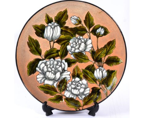 Christopher Dresser (Scottish, 1834-1904) for Linthorpe Pottery: A Charger, painted by Alex Burns, with white blossom, impres