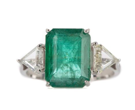 EMERALD AND DIAMOND RING,the emerald cut emerald of approximately 4.58 carats, flanked by two trillion cut diamonds totalling