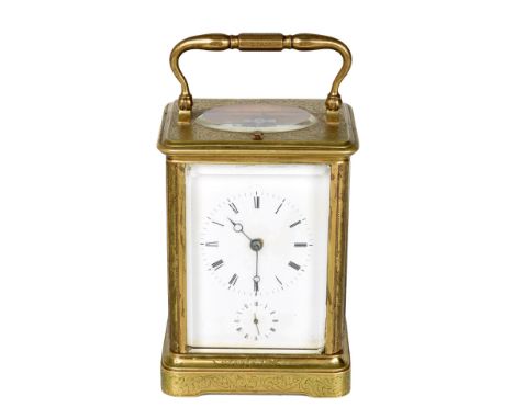 A 19th century brass carriage clock with foliate engraving. The brass framed clock has bevelled glass panels to sides and ova