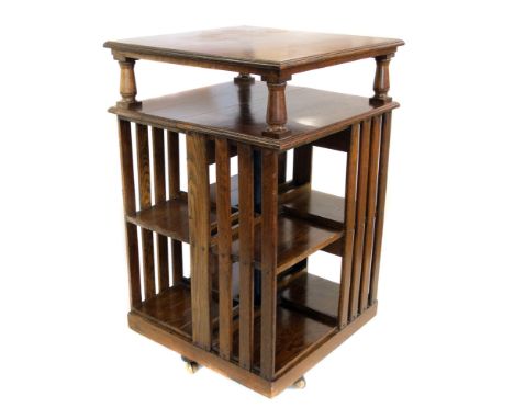 Edwardian oak revolving bookcase, square section top shelf supported on turned columns, two stage bookshelves all standing on