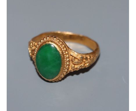 A Chinese yellow metal and cabochon jade set dress ring, with closed back setting stamped with character marks and 24k, size 