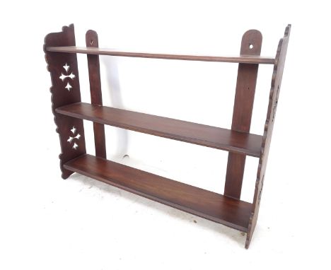 An Arts and Crafts style 3-tier hanging shelf, with pierced cut-out sides 