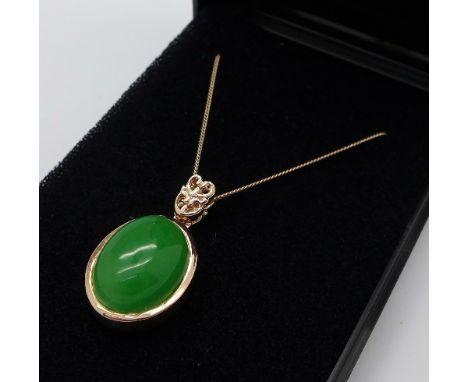 A silver gilt and jade pendant set with one diamond on the reverse, with chain
