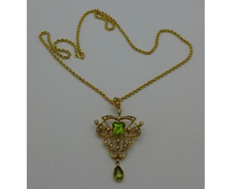 An Edwardian yellow metal set, peridot and seed pearl pendant/brooch on a 9ct gold rope chain, weight of pendant 7.4g, weight