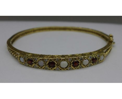 A 9ct gold, opal, garnet and white stone bangle, 12.6g