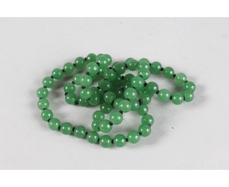 A STRING OF JADE BEADS. 28ins long.