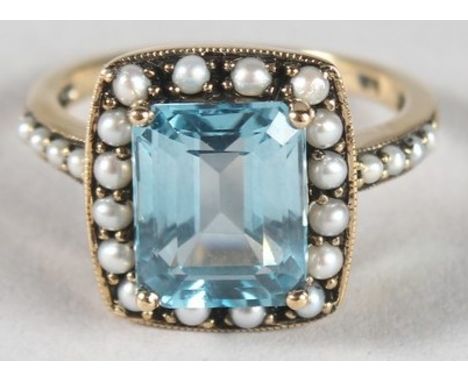A 9CT GOLD, BLUE TOPAZ AND SEED PEARL RING.