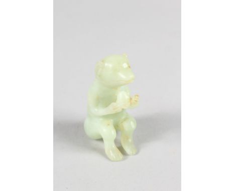 A CHINESE CARVED JADE MONKEY.