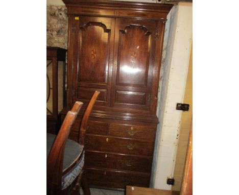 A 19th century oak linen press with inlaid decoration and ivory escutcheon, twin arched doors revealing sliding drawers, abov