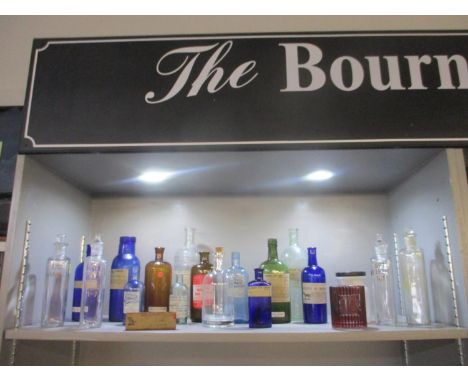 A collection of 19 chemist glass bottles of various shapes and sizes to include four with engraved and white enamel chemical 