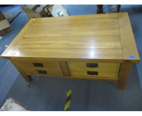 A contemporary light oak coffee table with four drawers on shaped block feet 50 x 119.5 x 70cm, along with a contemporary lig