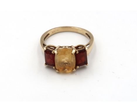 A 9ct gold citrine and garnet three stone ring. Size N 1/2. Weight 2.79 grams. 