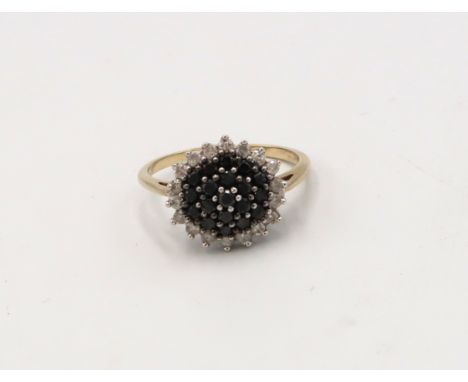 A 9ct gold diamond and black diamond cluster ring. Size U. Weight 4.0 grams. 