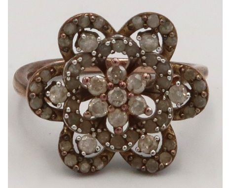 A brilliant cut diamond flower head ring. Stamped 925. Size P. Weight 4.27 grams. 