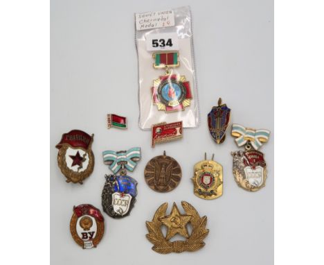A group of Soviet enamel badges and a Chernobyl medal. 