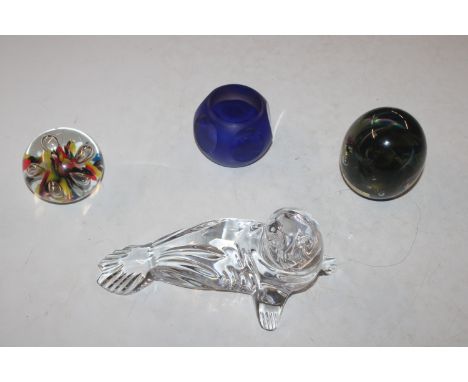 A Waterford glass model of a seal; a Kerry glass paperweight; a Caithness "Mystique" paperweight and one other