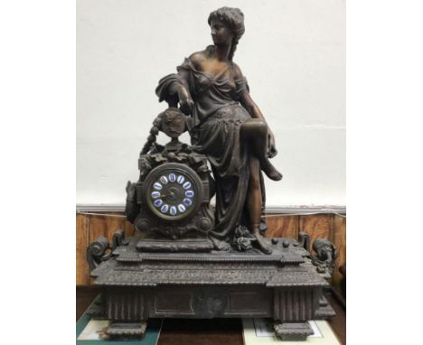 A large and impressive 19th century patinated spelter figural mantel clock modelled with a classical maiden seated next to an